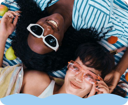 Two people with sunglasses laying side by side. 