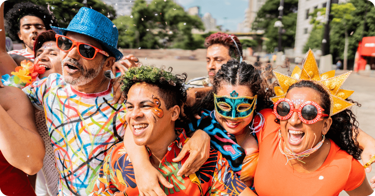 Partygoers at a bloco (street party) in the evening, smiling and enjoying the festivities.