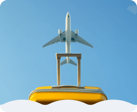 A yellow suitcase, with an airplane flying overhead.