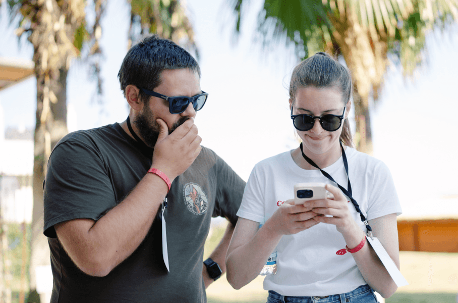 Los empleados de Saily se reunieron alrededor de un teléfono durante un evento empresarial.