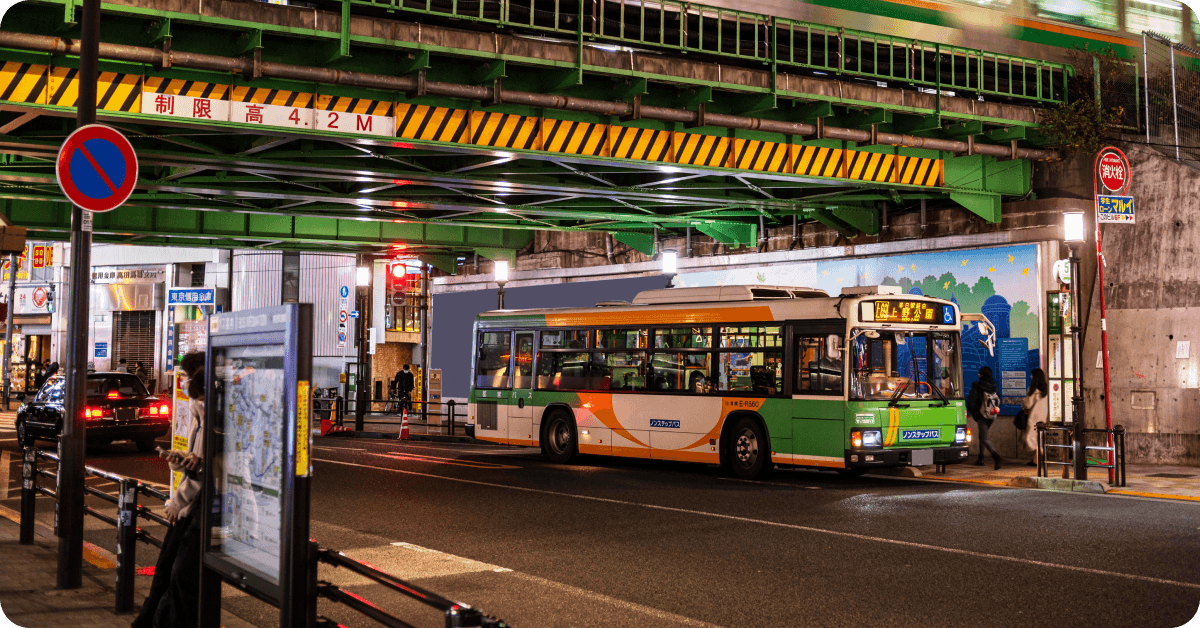 A bus in a stop under a bridge