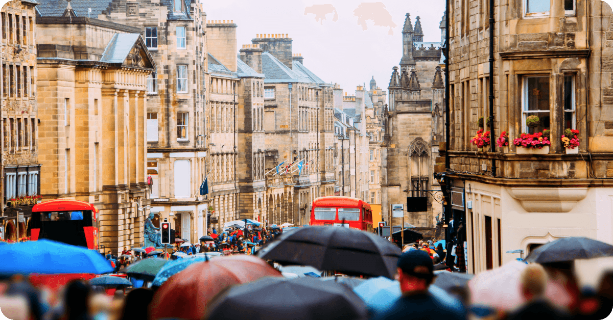 A UK city bustles with crowds on a rainy day.