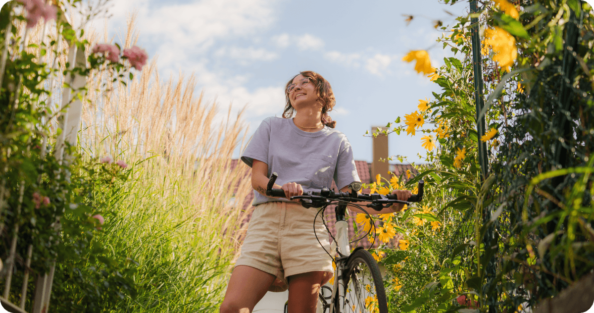 A woman with a bike in a park.