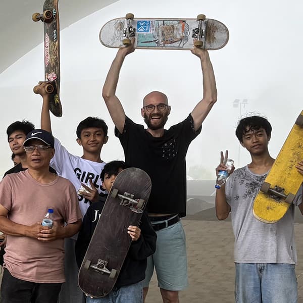 Skateboarding mentor with local youth during community outreach, supporting skills development and connection.