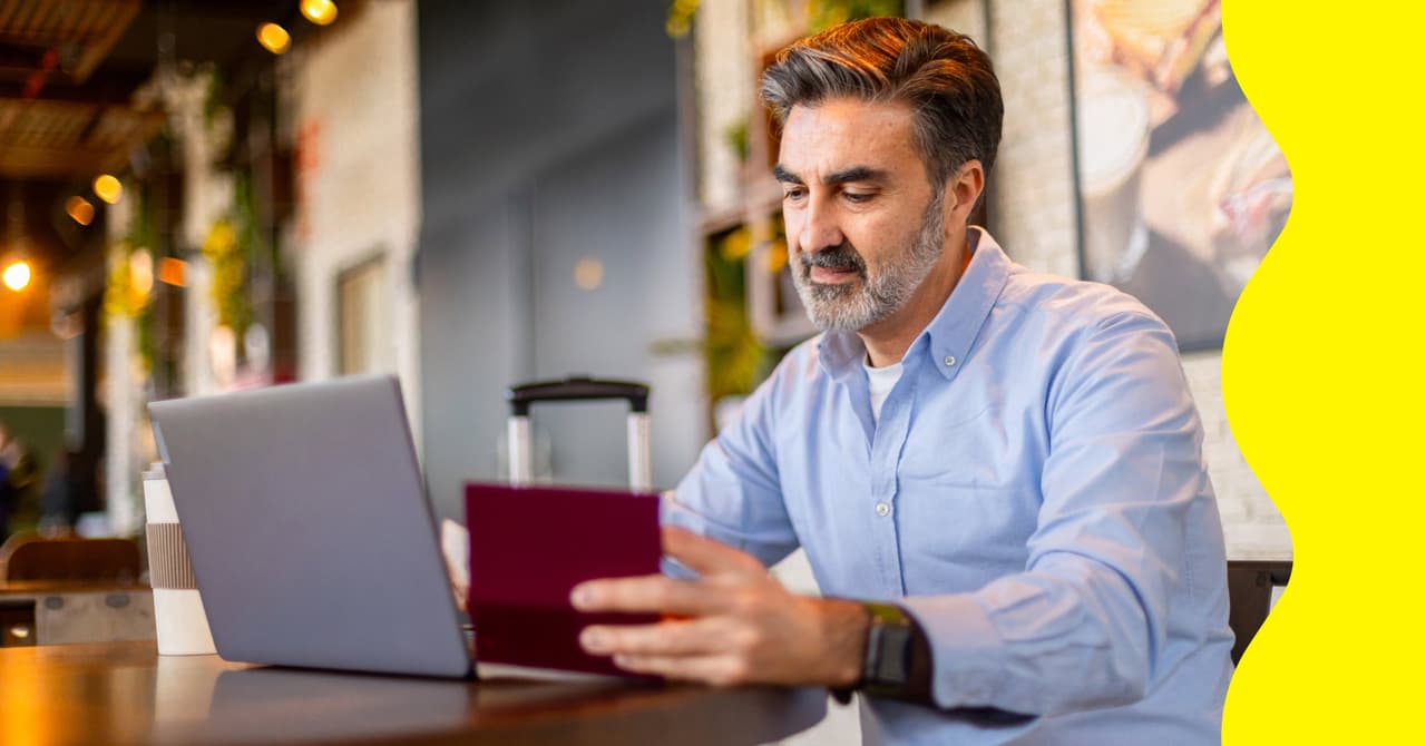 A man entering his passport details on a computer using public Wi-Fi.