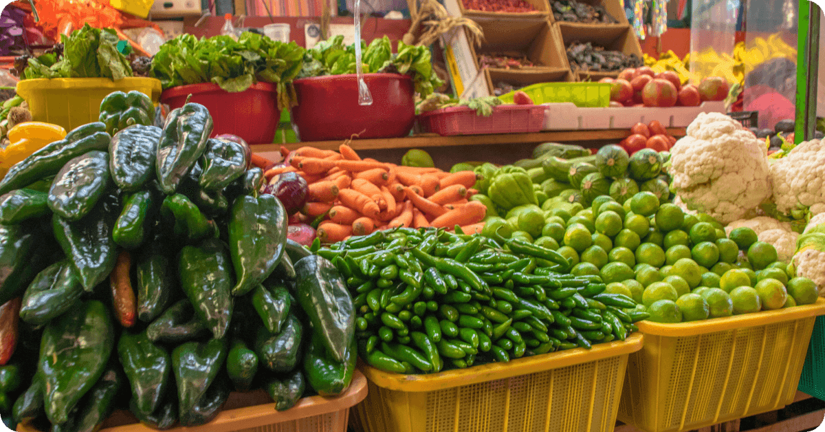 Traditional Mexican market scene featuring fruit, produce, and vendors