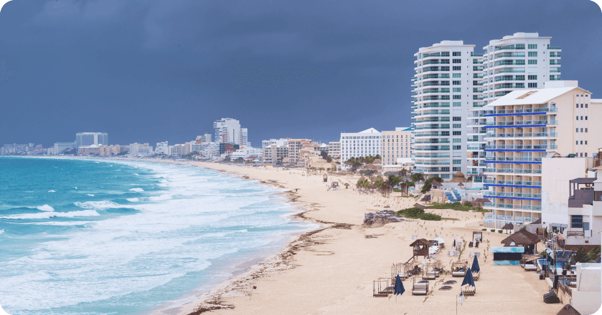 A stormy sky is visible over a beach in Cancún.