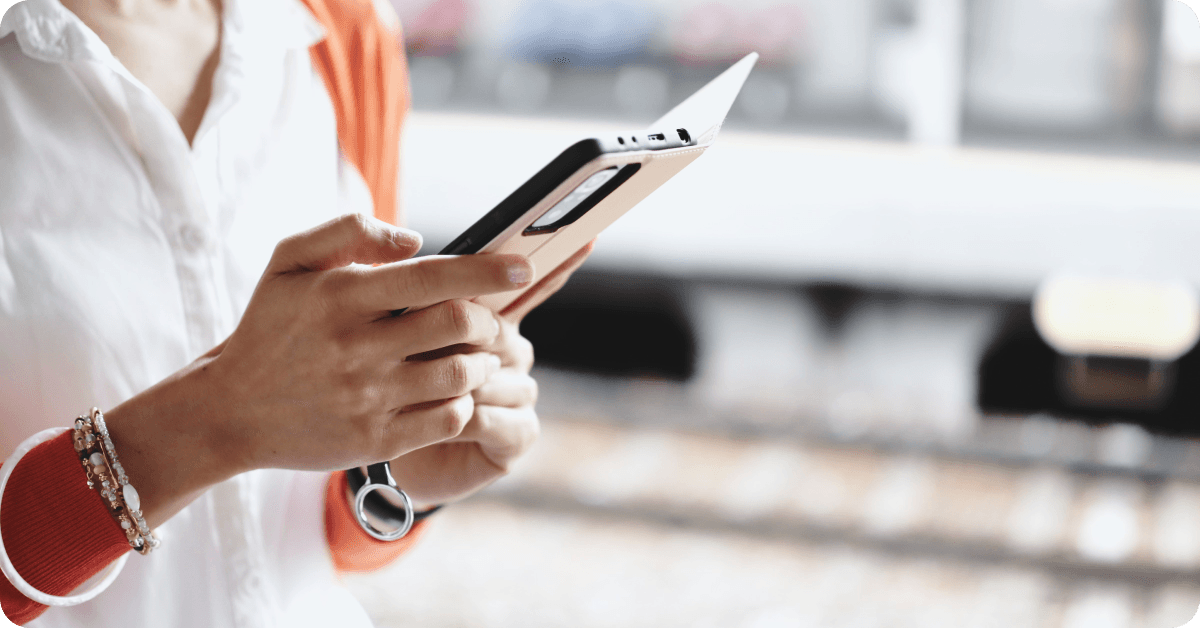 A person using their phone on a train platform in Japan.